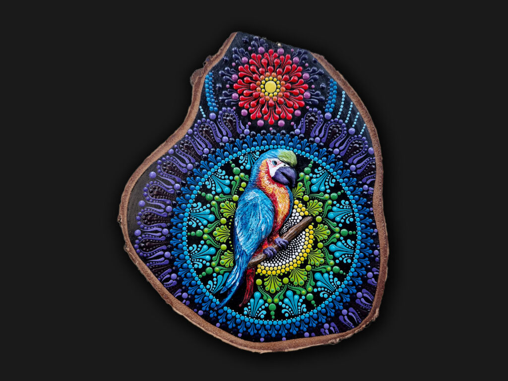 ęcznie malowana mandala dot painting z papugą na plastrze drewna. Kolorowa geometria sakralna i symbolika ekspresji.