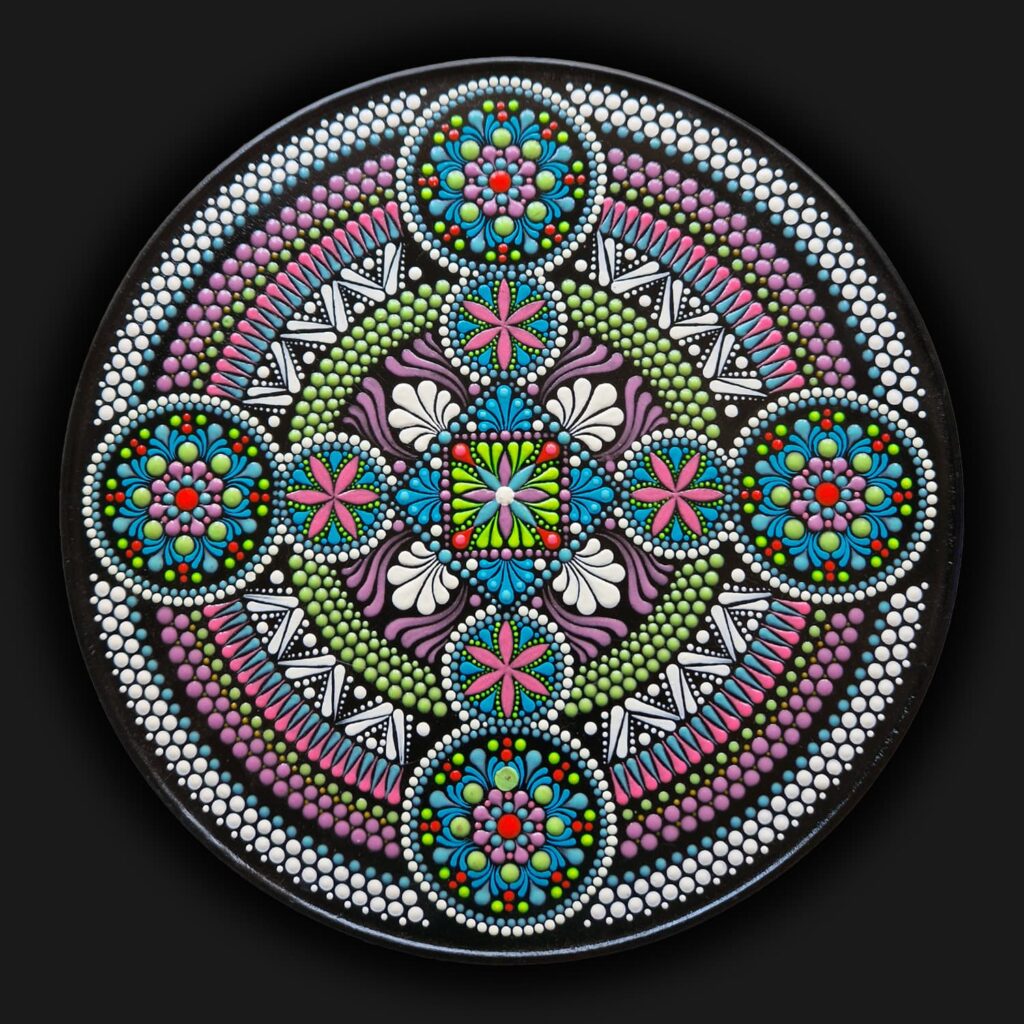 Okrągła mandala dot painting namalowana neonowymi, fluorescencyjnymi farbami w kolorach różu, zieleni i błękitu.